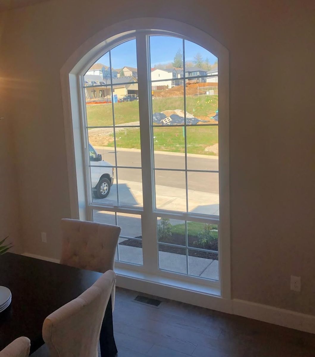 Tall arched dining window with divided-light grids and a painted extension jamb