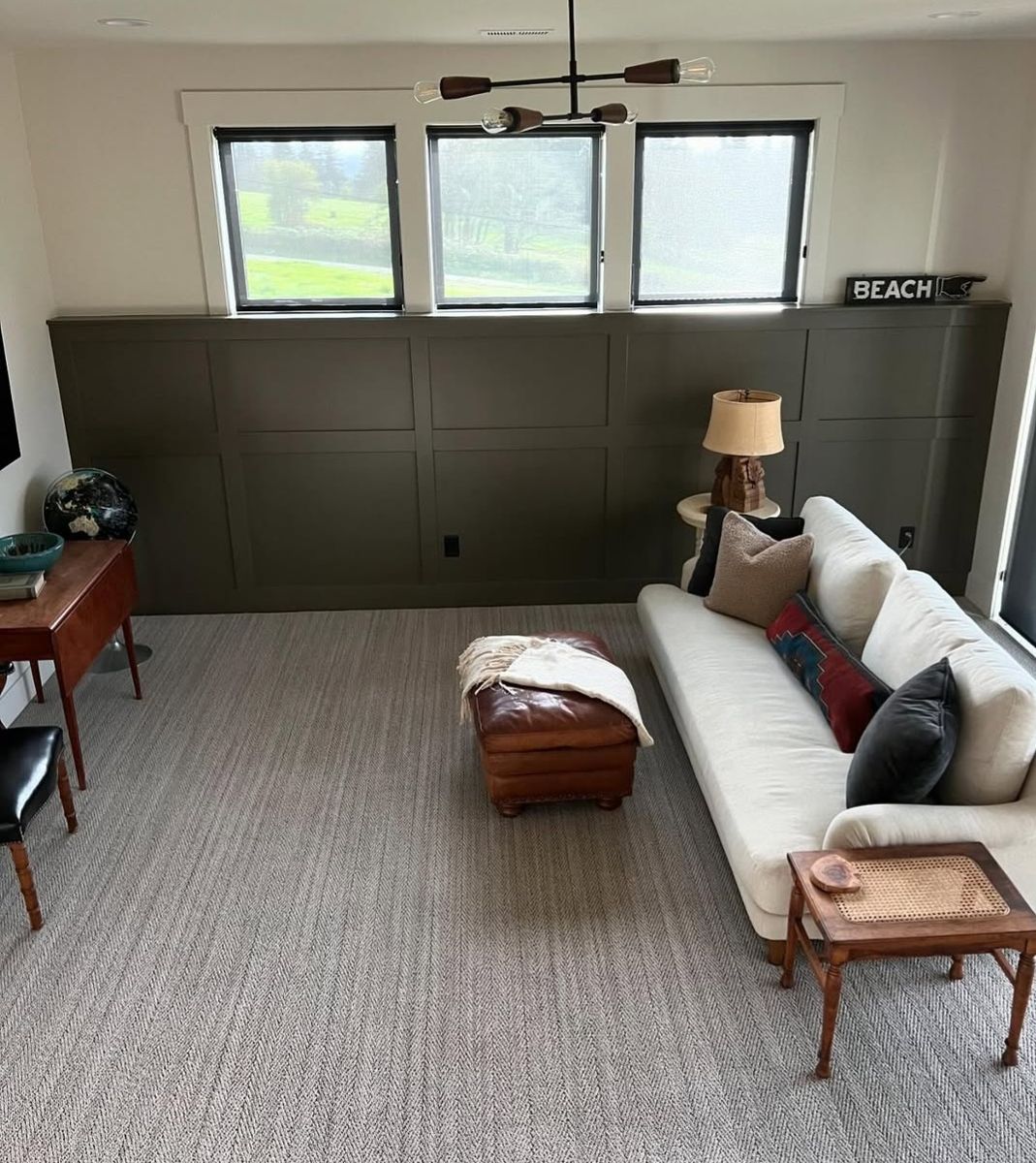 Family room with olive board-and-batten wainscot running under a band of transom windows