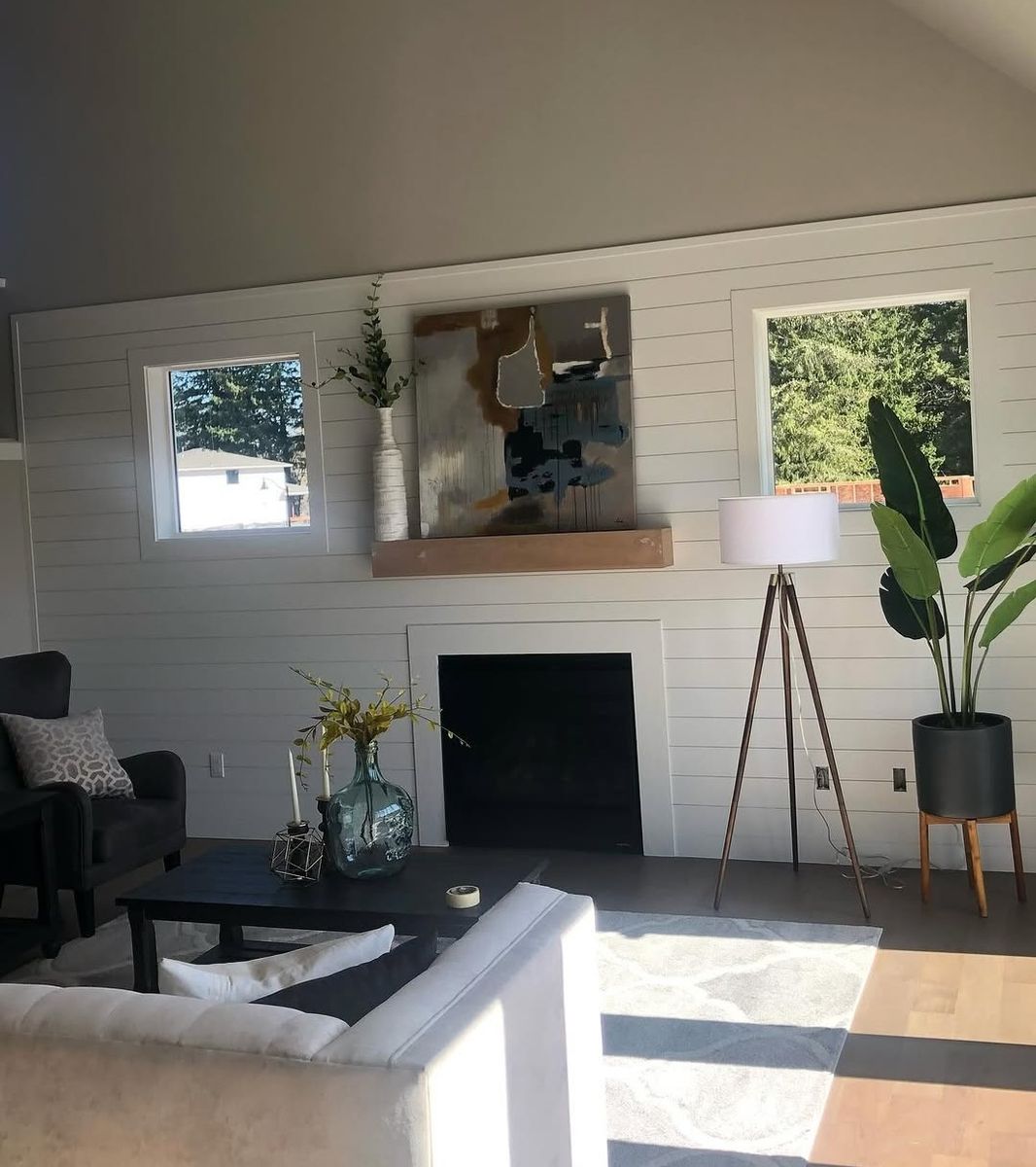 Living room shiplap wall running full height behind a fireplace with a floating cedar mantel